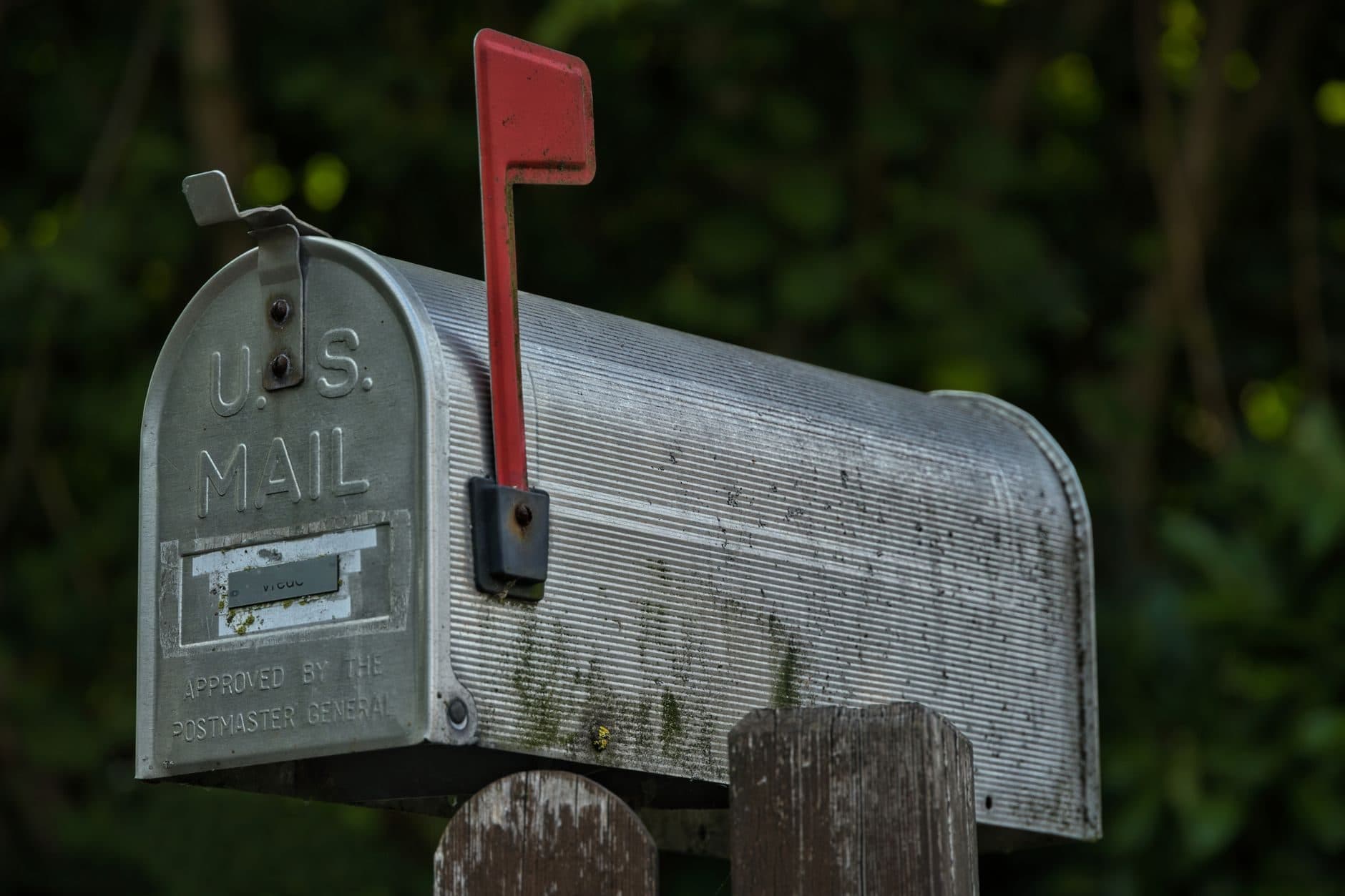A metal rural mailbox with its red flag raised